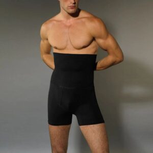 Man wearing black high-waisted compression shorts standing against a gray background.