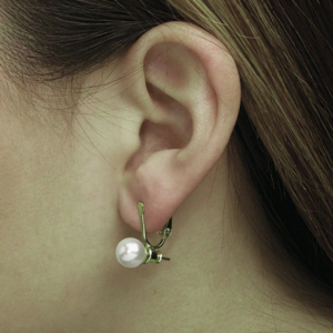 Close-up of an ear wearing a pearl drop earring.