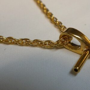 Close-up of a gold chain necklace with a bar toggle clasp.